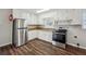 Efficient kitchen with stainless steel appliances, white cabinetry, and sleek hardwood floors at 8586 Taylor Rd, Riverdale, GA 30274