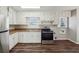 Efficient kitchen with stainless steel appliances, white cabinetry, and sleek hardwood floors at 8586 Taylor Rd, Riverdale, GA 30274