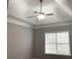 Bedroom featuring a tray ceiling, ceiling fan, and window with natural light at 106 Creek Crossing Ln, Temple, GA 30179