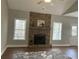 Cozy living room featuring a stone fireplace, hardwood floors, and natural light from two large windows at 106 Creek Crossing Ln, Temple, GA 30179