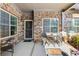 Charming covered porch with brick, a small table set, and beautiful plants at 120 Chastain Nw Rd # 608, Kennesaw, GA 30144
