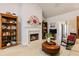 Cozy living room with a fireplace, bookshelves, and an ottoman at 120 Chastain Nw Rd # 608, Kennesaw, GA 30144