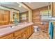 Bathroom featuring wood paneled walls, linoleum flooring, and vanity with double sinks and a large mirror at 1288 Reavesville Rd, Bowdon, GA 30108