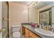 Neutral bathroom featuring a shower, toilet, vanity, and a well-lit mirror at 1288 Reavesville Rd, Bowdon, GA 30108