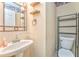 Bathroom with pedestal sink, toilet, mirror and open shelving for storage at 1288 Reavesville Rd, Bowdon, GA 30108