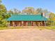Charming log cabin with a metal roof, rocking chairs, and a covered porch at 1288 Reavesville Rd, Bowdon, GA 30108