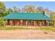 Charming log cabin with a metal roof, rocking chairs, and a covered porch at 1288 Reavesville Rd, Bowdon, GA 30108