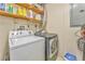 Functional laundry room with washer, dryer, shelving, and utility accessories at 1288 Reavesville Rd, Bowdon, GA 30108