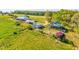 A wide view showcasing multiple outbuildings on a verdant, expansive property at 1288 Reavesville Rd, Bowdon, GA 30108