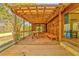 Spacious covered porch with a wooden floor, table and bench seating, perfect for outdoor enjoyment at 1288 Reavesville Rd, Bowdon, GA 30108