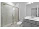 This bathroom features a glass-enclosed shower, toilet, and vanity with a large mirror and gray cabinets at 1815 Wellston Dr, Lawrenceville, GA 30043