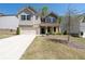 Beautiful two-story home featuring stone accents, a front porch, two-car garage, and landscaped lawn at 1815 Wellston Dr, Lawrenceville, GA 30043