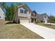 Inviting two-story home with stone accents, a well-manicured lawn, and a two-car garage at 1815 Wellston Dr, Lawrenceville, GA 30043