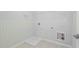 Bright laundry room featuring tile accent wall, hookups, tile flooring, and ample space at 1815 Wellston Dr, Lawrenceville, GA 30043