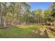 Large, fenced backyard with mature trees, offering a private and serene outdoor space at 209 Red Fern Ct, Canton, GA 30114