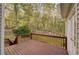 Inviting wooden deck with railings offers outdoor living space and views of the green, wooded backyard at 209 Red Fern Ct, Canton, GA 30114