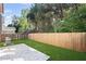 Backyard featuring a manicured lawn, patio, grill, and privacy fence surrounded by lush trees at 261 Highland Village Ln, Woodstock, GA 30188