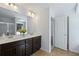 Well-lit bathroom with double vanities, a large mirror, and modern fixtures at 261 Highland Village Ln, Woodstock, GA 30188