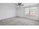 Bedroom with gray carpet and a ceiling fan, next to a bright window with a view of the outdoors at 261 Highland Village Ln, Woodstock, GA 30188