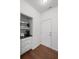Butler pantry with white cabinets, dark countertops, stainless microwave, and hardwood floors at 261 Highland Village Ln, Woodstock, GA 30188