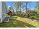 Manicured backyard with lush green grass, deck area and mature trees at 5265 Bentley Hall Dr, Alpharetta, GA 30005