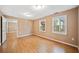 Finished basement with two windows offering natural light, laminate flooring and neutral colors at 5265 Bentley Hall Dr, Alpharetta, GA 30005