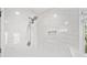 Shower featuring white marble tiling, shower head, and built-in niche at 5265 Bentley Hall Dr, Alpharetta, GA 30005