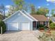 Charming single-story home with blue siding, brick accents, and a two-car garage, enhanced by professionally landscaped front yard at 5265 Bentley Hall Dr, Alpharetta, GA 30005