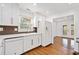 Contemporary kitchen with white cabinetry, hardwood floors, a sleek countertop, and a view into the dining area at 5265 Bentley Hall Dr, Alpharetta, GA 30005
