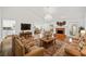 Spacious living room with a brick fireplace, hardwood floors, and a view of the dining area and kitchen at 5265 Bentley Hall Dr, Alpharetta, GA 30005