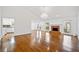 Open-concept living room featuring hardwood floors, a brick fireplace, and an elegant chandelier at 5265 Bentley Hall Dr, Alpharetta, GA 30005
