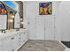 Modern bathroom with double vanity, decorative mirrors, tiled floors and walk-in shower at 1774 Vesta Ave, Atlanta, GA 30337