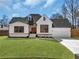 Charming white brick home features a well-manicured lawn and a two-car garage at 1774 Vesta Ave, Atlanta, GA 30337