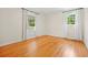 Bright, empty bedroom features beautiful hardwood floors and natural light streaming through two windows at 262 E Main St, Rutledge, GA 30663