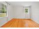 Bright, empty bedroom features beautiful hardwood floors and natural light streaming through two windows at 262 E Main St, Rutledge, GA 30663
