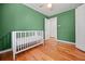 Bedroom with crib and hardwood floors at 262 E Main St, Rutledge, GA 30663