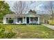 Charming single-story home features a covered porch, blue trim, and well-maintained lawn at 262 E Main St, Rutledge, GA 30663