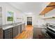 Modern kitchen features stainless appliances, floating wood shelves, and view to laundry at 262 E Main St, Rutledge, GA 30663