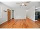 Spacious living room with hardwood floors, wood door, ceiling fan, and access to kitchen at 262 E Main St, Rutledge, GA 30663