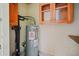 Water heater situated between cabinets, possibly in a utility closet or unfinished area at 262 E Main St, Rutledge, GA 30663