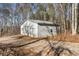 Detached two-car garage with a white exterior and dual doors, set amidst a wooded landscape at 4941 N Helton Rd, Winston, GA 30187