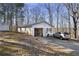 Exterior view of a garage with storage and a car parked in the driveway at 4941 N Helton Rd, Winston, GA 30187