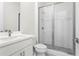 A modern bathroom featuring a walk-in shower, white cabinets, tile, and a sink at 779 Keystone Dr, Woodstock, GA 30188