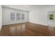 Spacious, sunlit room featuring wood floors, large windows, and an open doorway leading to another room at 779 Keystone Dr, Woodstock, GA 30188
