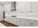 A modern kitchen features white cabinetry, a gas range, stainless steel appliances, and wood flooring at 779 Keystone Dr, Woodstock, GA 30188