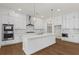 A well-designed kitchen with white cabinets, quartz countertops, stainless steel appliances, and hardwood flooring at 779 Keystone Dr, Woodstock, GA 30188