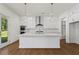 A modern kitchen with white cabinets, stainless steel appliances, a large island, and hardwood floors at 779 Keystone Dr, Woodstock, GA 30188