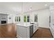 Open-concept kitchen boasts a large island, stainless steel appliances, hardwood floors, and abundant natural light at 779 Keystone Dr, Woodstock, GA 30188