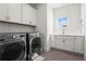 Bright laundry room featuring modern washer and dryer, sink, and ample cabinet space for convenient storage at 779 Keystone Dr, Woodstock, GA 30188