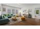 Bright, open-concept living room with a teal couch, modern area rug, and desk by the window at 779 Keystone Dr, Woodstock, GA 30188